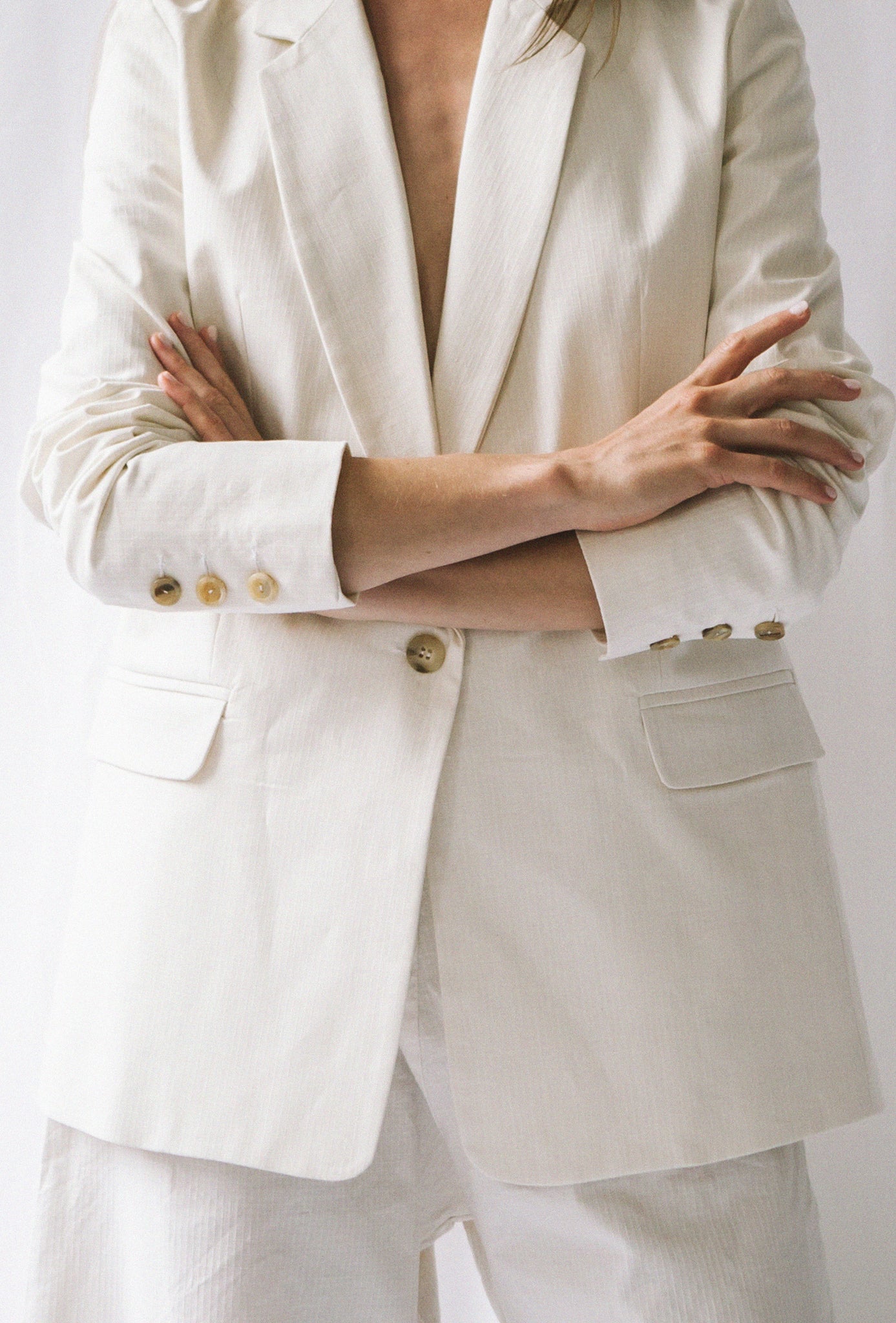 Veste blazer blanche écoresponsable. 3 Boutons vintages de seconde main sur le bout des manches et 1 pour fermer la veste.